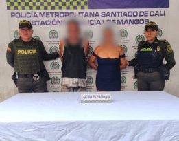 En la fotografía aparecen los capturados junto a dos uniformados de la Policía. En la parte superior está un banner de la Policía Nacional