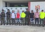 En la imagen se ven varias personas detenidas bajo custodia de varios integrantes del Ejército y la Policía Nacional. Detrás hay varios backings institucionales.