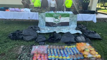 Los capturados se encuentran de frente y custodiados por uniformados de la Policía y Ejército Nacional. Detrás de la foto hay un backing del Ejército Nacional y en la foto se observa parte del material incautado.