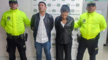 En la imagen están la mujer y el hombre capturados en medio de dos servidores de la Policía Nacional