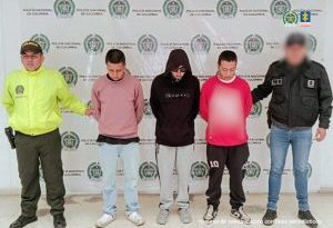 En la fotografía aparecen los tres capturados junto a un servidor del CTI y un uniformado de la Policía. En la parte superior está un banner de la Policía Nacional