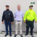 El capturado se encuentra de frente y con el rostro cubierto y custodiado por un servidor del Cuerpo Técnico de Investigación CTI y de la Policía Nacional.