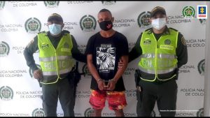 Uniformados de la Policía Nacional custodian a los hoy sentenciados a 43 años de cárcel tras su captura en Barranquilla. En la imagen se ven tres personas.