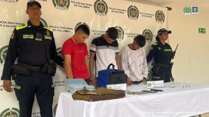 Los tres capturados se encuentran de frente y custodiados por dos uniformados de la Policía Nacional. En la foto se observan los objetos que estos delincuentes se habían hurtado.