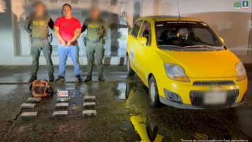 Se visualiza al capturado junto a dos uniformados de la Policía Nacional. Frente a ellos la sustancia incautada. Detrás de ellos el banner que identifica a la Policía Nacional.