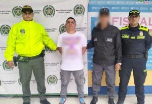 El capturado se encuentra de frente y custodiado por un servidor del Cuerpo Técnico de Investigación CTI y dos uniformados de la Policía Nacional.