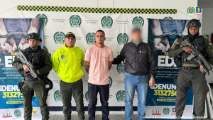 En la fotografía aparece el capturado junto a un funcionario del CTI y tres uniformados de la Policía Nacional. En la parte superior está un banner de la Policía Nacional.