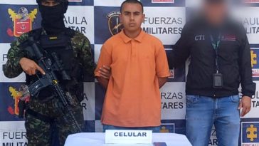 El capturado se encuentra de frente y custodiado por un servidor del Cuerpo Técnico de Investigación CTI y un uniformado del Ejército Nacional.