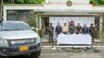 Los capturados se encuentran de frente y custodiados por servidores del Cuerpo Técnico de Investigación CTI junto a uniformados del Ejército Nacional. En la foto se ve parte del material incautado como munición, fusiles, dinero, celulares y la camioneta.