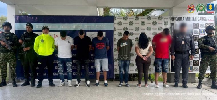 En las fotografías aparecen seis de los siete capturados junto a dos servidores del CTI y dos agentes de la Policía. En la parte superior están un banner de la Fiscalía General y otro banner de la Policía Nacional.