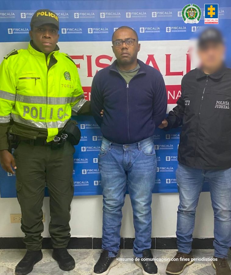 En la fotografía se aprecia de pie y con los brazos atrás a Harold Aristides Olmedo Solís. Viste Buso azul oscuro de cierre e internamente se ve camiseta de color verde oliva; también usa jean azul y zapatillas negras con zuela blanca. A su izquierda hay un servidor del CTI de la Fiscalía y a la derecha un uniformado de la Fiscalía. Detrás de ellos hay un pendón institucional de la Fiscalía.