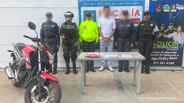 En el centro de la imagen aparece el hombre capturado, frente a él una motocicleta. A ambos costados hay miembros del Ejército, el CTI de la Fiscalía y la Policía. En total 5 personas y el capturado.