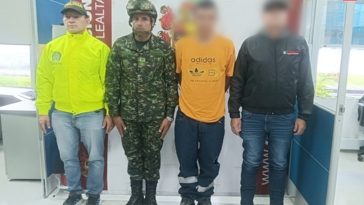 En la imagen se ve una persona detenida bajo custodia de un integrante de la Policía, Ejército y CTI. Detrás suyo, un backing institucional.