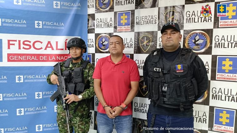 El capturado aparece en el centro de la imagen, rodeado de miembros del Ejército y la Fiscalía. Al fondo se ven banner de las dos entidades.