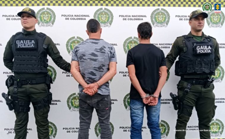 En la fotografía se aprecia de espaldas a la cámara, con los brazos atrás y esposados  a Jorge Luis Ortiz Escobar y Juan Camilo Londoño Ortiz. Uno viste camiseta gris, camuflada y de manga corta; jean gris oscuro y zapatillas negras. El otro viste camiseta de manga corta de color negro, jean azul y zapatillas negras con blanco. A sus extremos hay uniformados de la Policía Nacional y en la parte posterior hay un pendón institucional de la Policía.