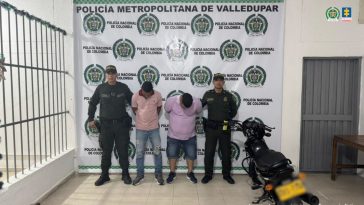 Los capturados se encuentran de frente y  custodiados por dos uniformados de la Policía Nacional. En la foto se ve de fondo un backing de la Policía Nacional y una de las motos utilizadas para cometer el hurto.