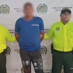 El capturado aparece con sus manos esposadas a la espalda y custodiado por unidades de la Policía Nacional.