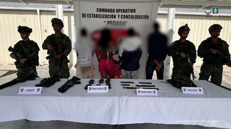 En la fotografía aparecen de espaldas a la cámara Andrés Felipe Valencia Ojeda y José Over Ortiz Ríos. A sus extremos hay uniformados de la Armada Nacional. En la parte delantera hay una mesa con mantel blanco y sobre ella se aprecian armas de fuego, proveedores, munición y un chaleco. En la parte posterior hay un pendón del Comando Operativo de Estabilización y Consolidación ‘Pegaso’, de la Armada Nacional.