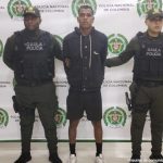 En la imagen está el procesado de cuerpo entero con dos servidores del Gaula de la Policía  a los lados