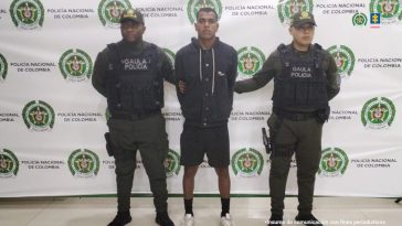 En la imagen está el procesado de cuerpo entero con dos servidores del Gaula de la Policía  a los lados