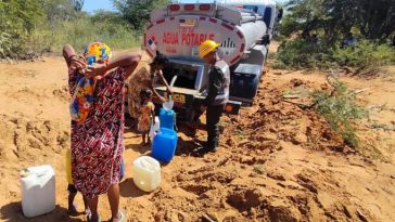 El preciado líquido llega en carro cisterna y los wayuu se acercan al vehículo con recipientes grandes y pequeños.