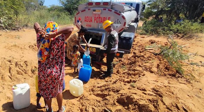 El preciado líquido llega en carro cisterna y los wayuu se acercan al vehículo con recipientes grandes y pequeños.