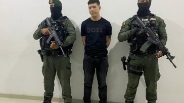 Se visualiza al capturado junto a dos uniformados de la Policía Nacional.