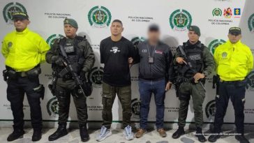 en la imagen se ve un hombre detenido bajo custodia de integrantes de la Policía Nacional y el CTI.