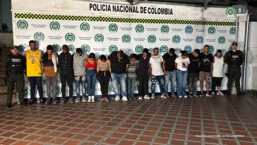 Los detenidos aparecen en la foto con funcionarios de la Policía y atrás un pendón con logos de la Policía Nacional.