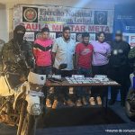 capturados de frente custodiados por investigador del CTI de Fiscalía, militares de ejército y de Fuerza Aérea delante mesa con material incautado, detrás banner de Fiscalía y de Gaula Militar.