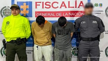 En la fotografía aparecen los dos capturados junto a un servidor del CTI y un uniformado de la Policía. En la parte superior está un banner de la Fiscalía General