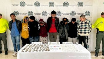 En la fotografía están los ocho capturados junto a dos uniformados de la Policía Nacional. En la parte posterior está una mesa con dosis de cocaína, marihuana y bazuco