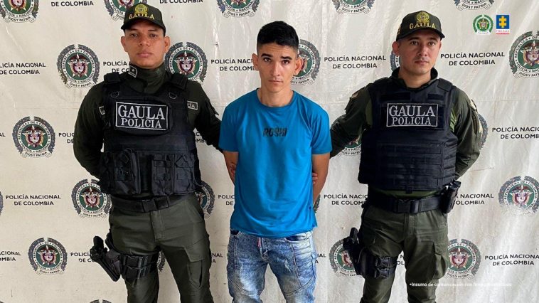 Dos uniformados de la Policía Nacional custodian an alias Yeison tras su captura en La Mesa (Cesar). 