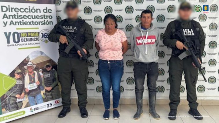 Los capturados se encuentran de frente y custodiados por uniformados del Gaula  de la Policía Nacional. Detrás se observa un backing de la Policía Nacional. 