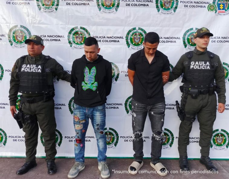 Los capturados se encuentran de  frente y custodiados por dos uniformados del Gaula de la Policía Nacional. 