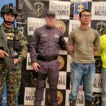 El hombre capturado aparece de pie, con las manos esposadas en la espalda. Está rodeado de miembros de la Policía, el Ejército y el CTI de la Fiscalía.